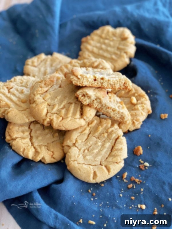A vibrant stack of freshly baked peanut butter cookies, perfectly golden with visible fork marks, ready to be enjoyed.