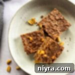 No Bake Chocolate Peanut Butter Cookie bars stacked on a cream colored plate.