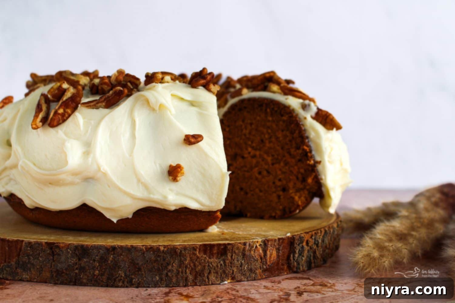 Pumpkin Bundt Cake with Cream Cheese Frosting (Cinderella Cake) on a wooden serving plate, another fantastic fall dessert option.
