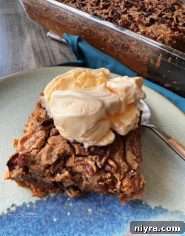 Close-up of a slice of Pumpkin Dump Cake with a golden brown topping and a creamy pumpkin base