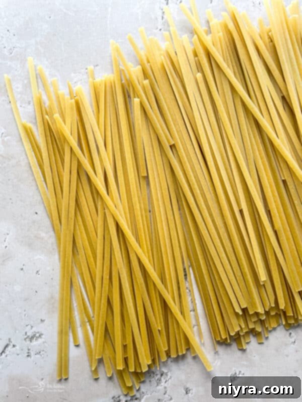 A generous serving of Instant Pot Fettuccine Alfredo in a white bowl, ready to be enjoyed.