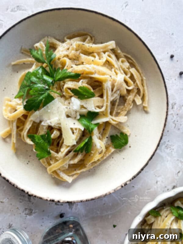 A close-up of creamy Instant Pot Fettuccine Alfredo in a bowl, showing the rich texture.