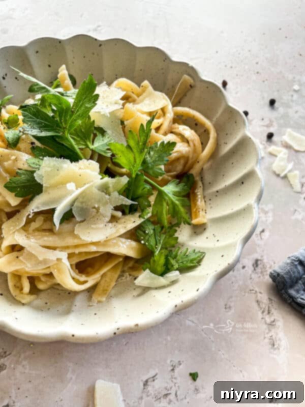 Two plates of Instant Pot Fettuccine Alfredo ready to be served, showcasing the rich sauce and pasta.