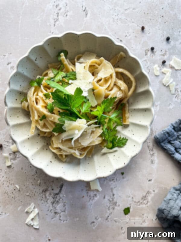 A serving of Instant Pot Fettuccine Alfredo, garnished with fresh parsley.