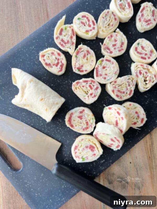 Slicing a chilled Reuben Style Tortilla Roll-Up into pinwheels