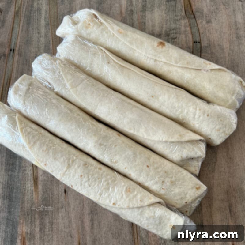 Rolled-up Reuben Style Tortilla Roll-Ups, tightly wrapped in plastic