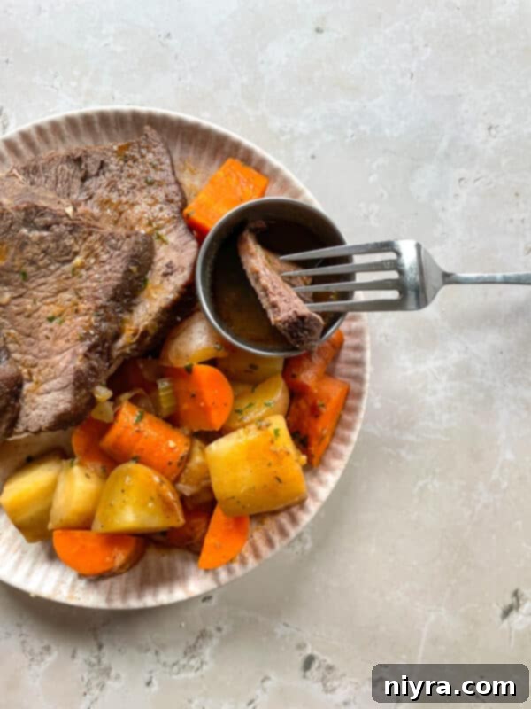 A close-up of the finished Bob Evans style pot roast, carved into thick slices, resting on a bed of tender vegetables, ready to be served with the rich, reduced gravy.