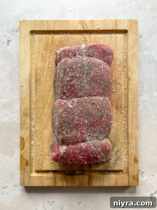 Close-up of a well-seared chuck roast browning in a Dutch oven on the stovetop, developing a flavorful crust.