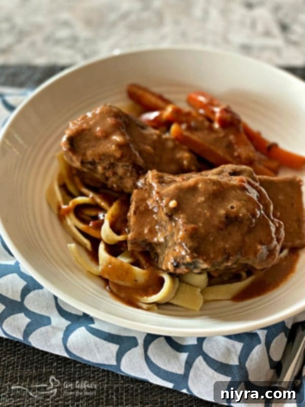 Braised Beef Short Ribs with Red Eye Gravy in a white bowl, another amazing recipe.
