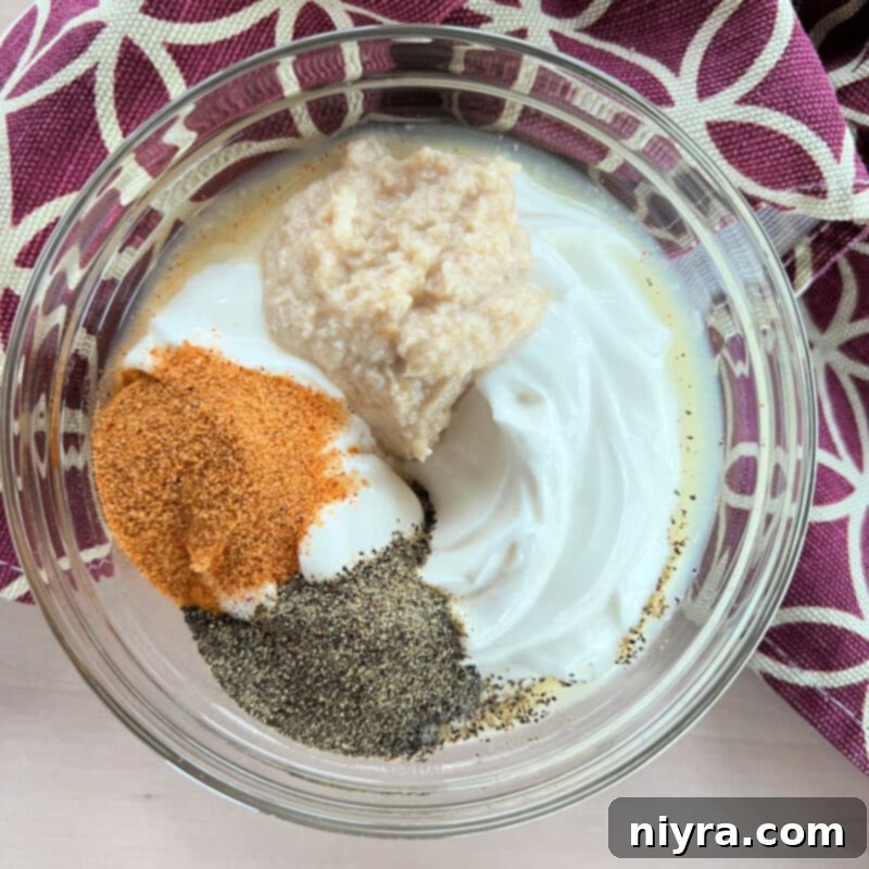 Ingredients laid out for homemade horseradish sauce: sour cream, horseradish, lemon juice, and seasonings.