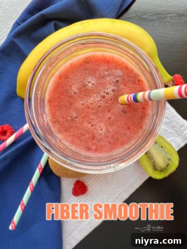 Hero shot of a high fiber smoothie in a glass with fruits in the background