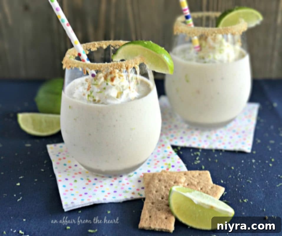 Side view of 2 key lime pie smoothies in glasses with lime wedges