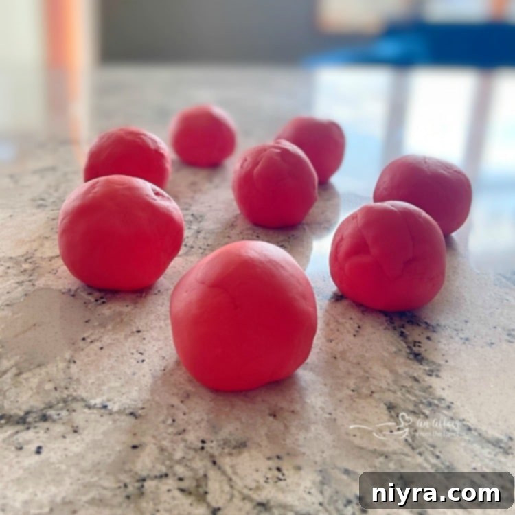Homemade Play-Doh in various vibrant colors, rolled and shaped.