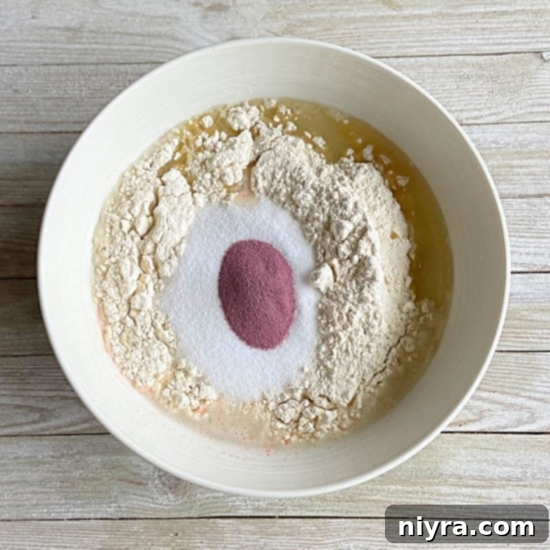 Combining dry ingredients for homemade Kool-Aid playdough in a bowl.