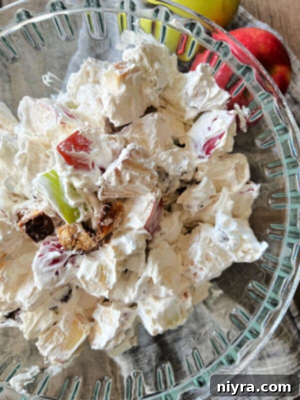 Snicker Apple Salad served in individual glass cups, garnished with extra Snickers pieces.