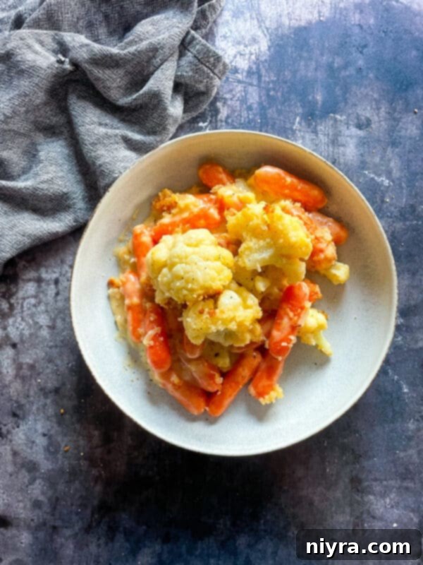 Ingredients for cauliflower and carrot gratin laid out on a kitchen counter, including chopped vegetables, cheese, and butter.