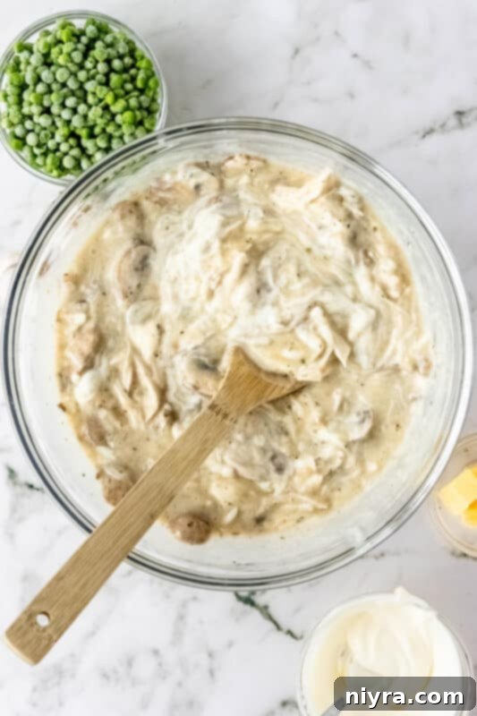 Various casserole ingredients, including shredded turkey, soups, and sour cream, in a large mixing bowl.