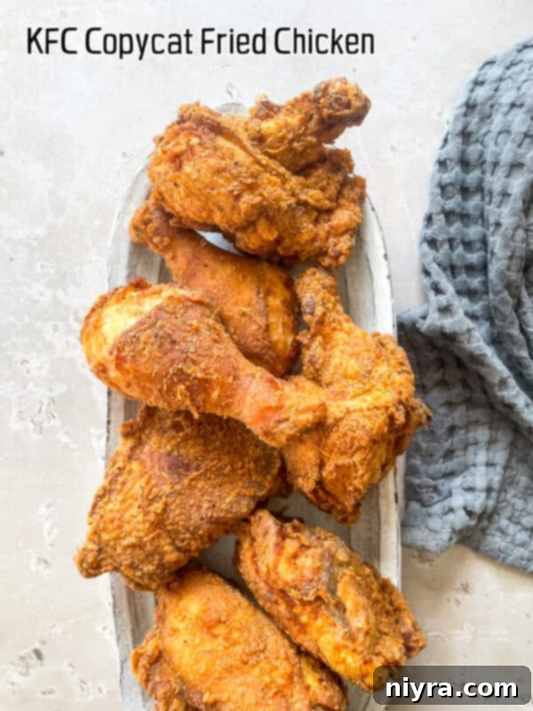 A vibrant hero shot of a platter of golden crispy KFC copycat fried chicken pieces.