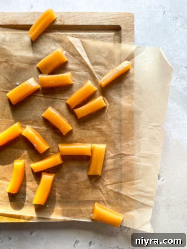 Homemade caramels cooling on a baking sheet, ready to be cut.