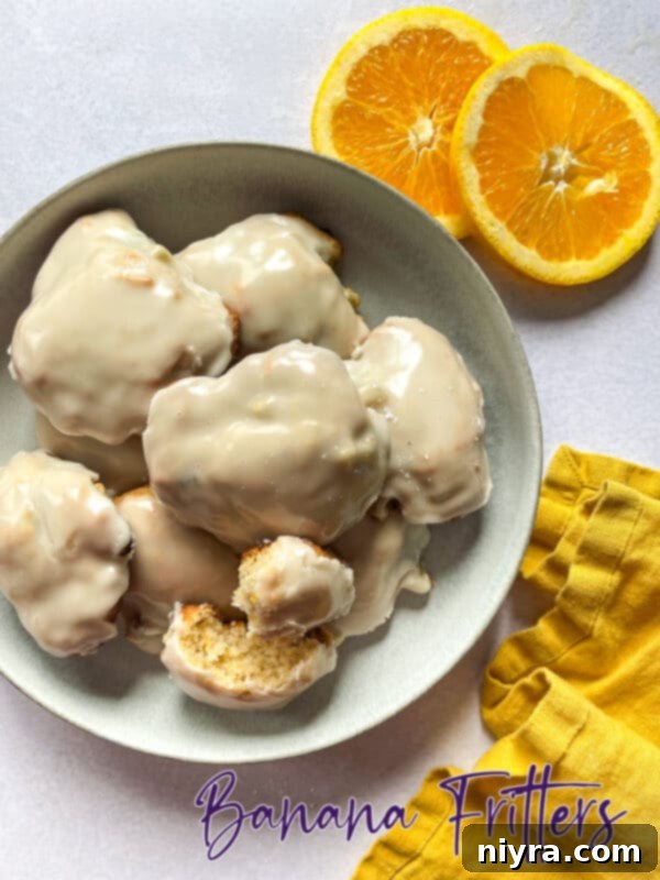 Warm Banana Bliss Bites 18 Hero shot of beautifully glazed baked banana fritters on a wooden board.