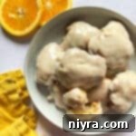 Warm Banana Bliss Bites 20 Stacked banana fritters in a white bowl.