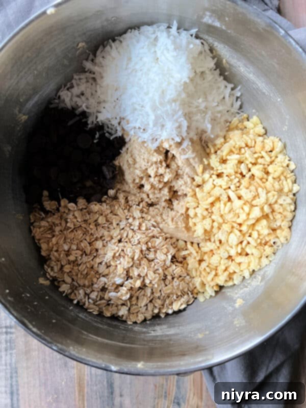 Mom's Scrumptious Cookies 9 Folding in Rice Krispies, coconut, oatmeal, and chocolate chips into cookie dough