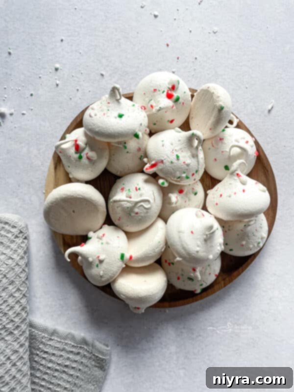 Minty Dream Clouds 2 Peppermint Meringues arranged on a festive holiday platter, showing their light and airy texture with crushed candy cane topping.