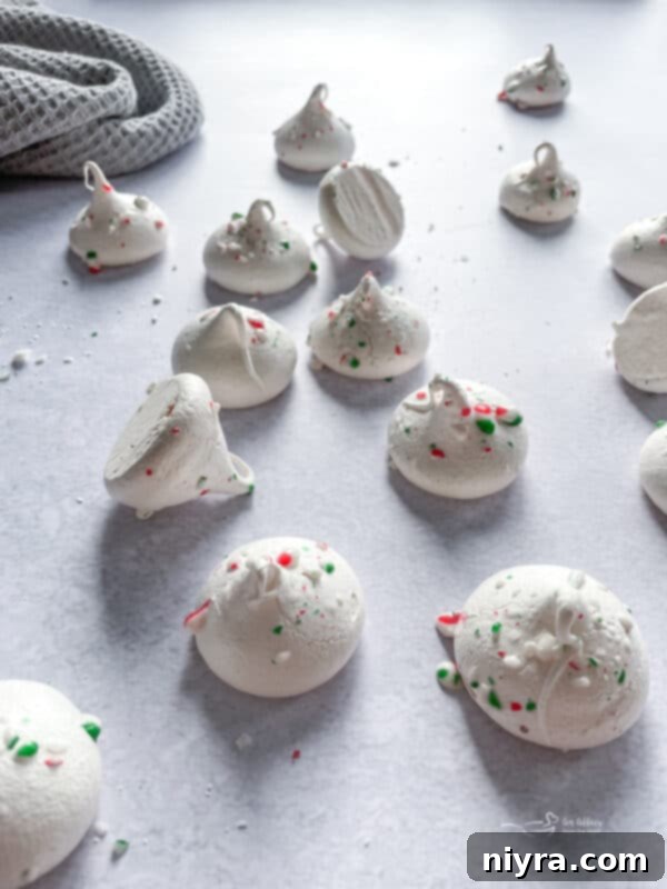 Minty Dream Clouds 3 Close-up of fluffy white peppermint meringues with crushed candy cane bits, ready for serving.