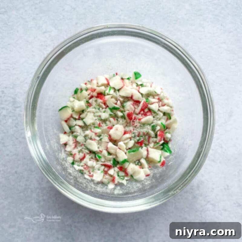 Minty Dream Clouds 6 Piping meringue mixture onto a parchment-lined baking sheet, forming small, uniform swirls.