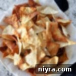Air fryer wonton chips in a napkin lined bowl.