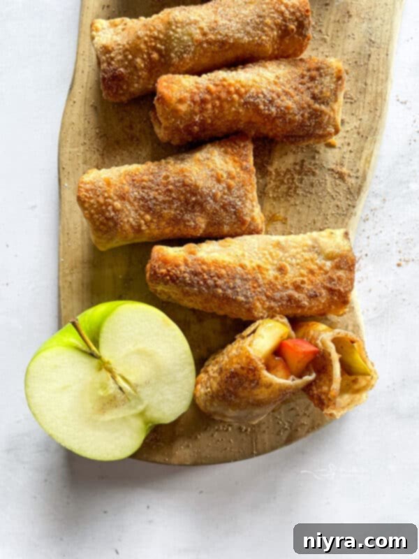 Air fryer apple pie egg rolls, golden and crispy, served with a dusting of powdered sugar.