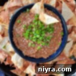 Asian bean dipped topped with green onions in a blue bowl.