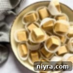 Peanut butter fudge stacked on a cream color dish.