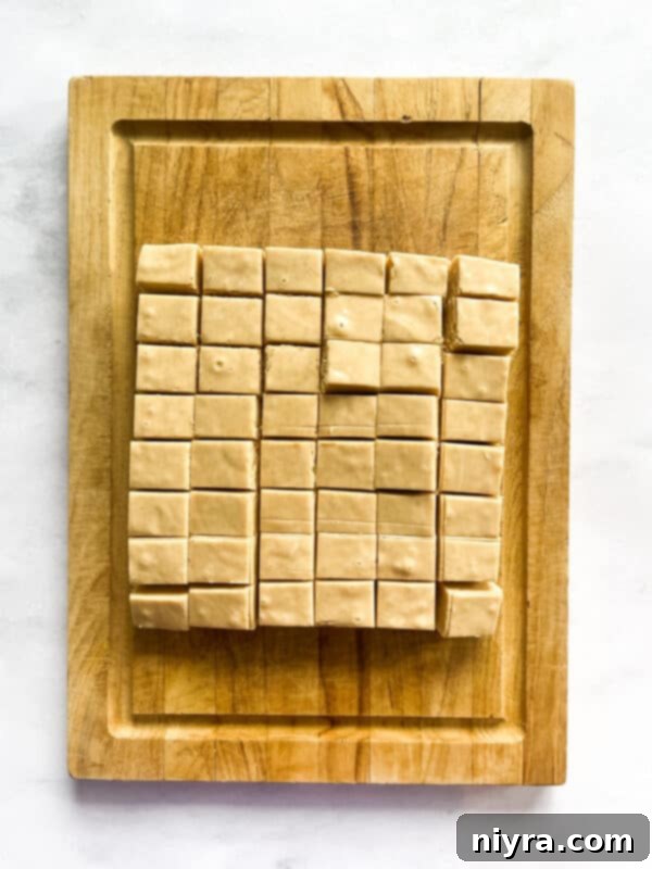 Peanut butter fudge setting in a pan inside the refrigerator