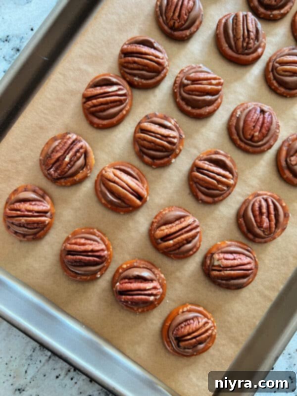 A tray of freshly baked Rolo pretzels with melted Rolo candies, before the M&Ms are pressed into them.