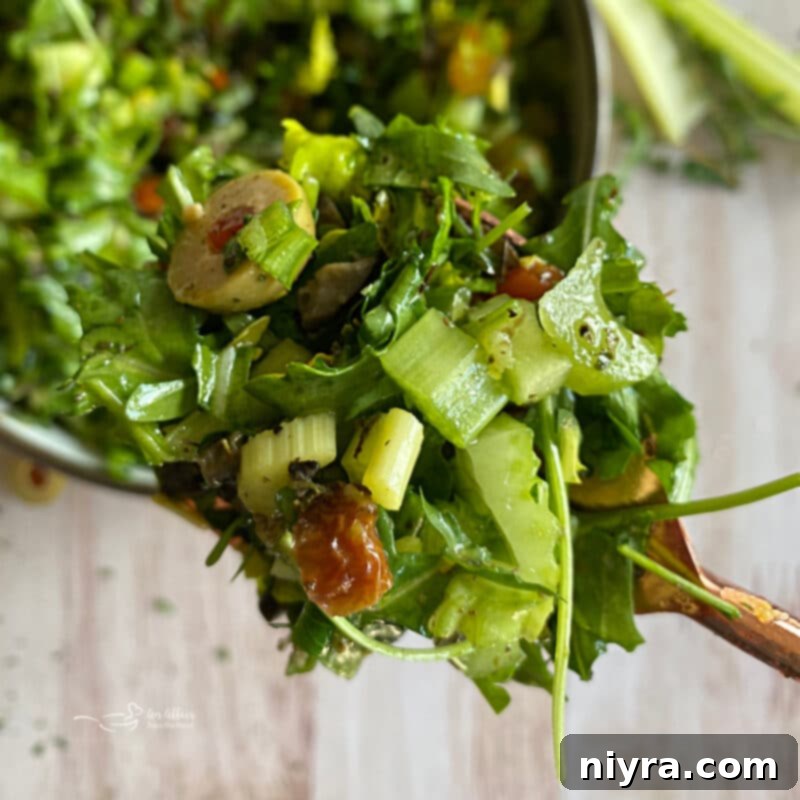 Bright Mediterranean Celery Olive Salad 3 Close-up of Mediterranean Celery Salad with Olives in a white bowl, showcasing the chopped celery, olives, apricots, and herbs.