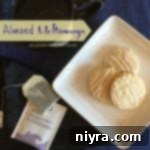 Buttery Almond Clouds 2 Overhead of cookies on a white plate with text "Almond Meltaways"