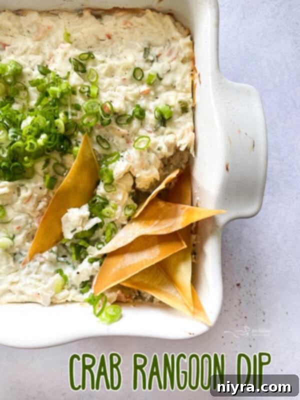 Close-up of a generously scooped portion of Crab Rangoon Dip with crispy wonton chips.