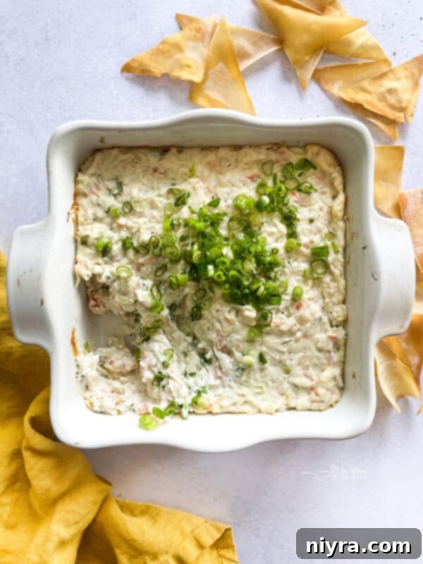 All the ingredients for Crab Rangoon Dip are mixed in a large bowl, showing the creamy texture and pieces of crab and green onion.