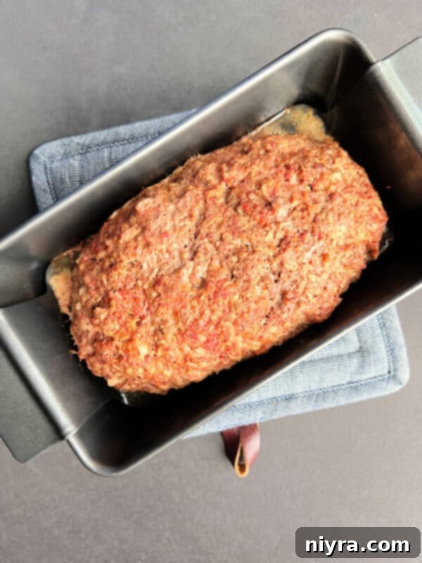 Reuben meatloaf formed in a loaf pan, covered with foil
