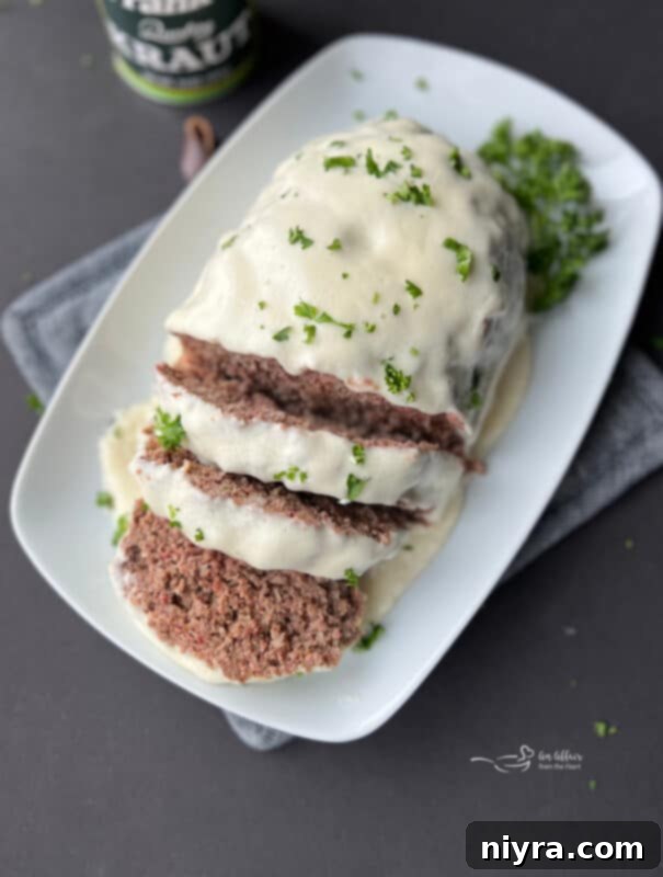 Reuben Meatloaf with Swiss Cheese Sauce on a rustic background