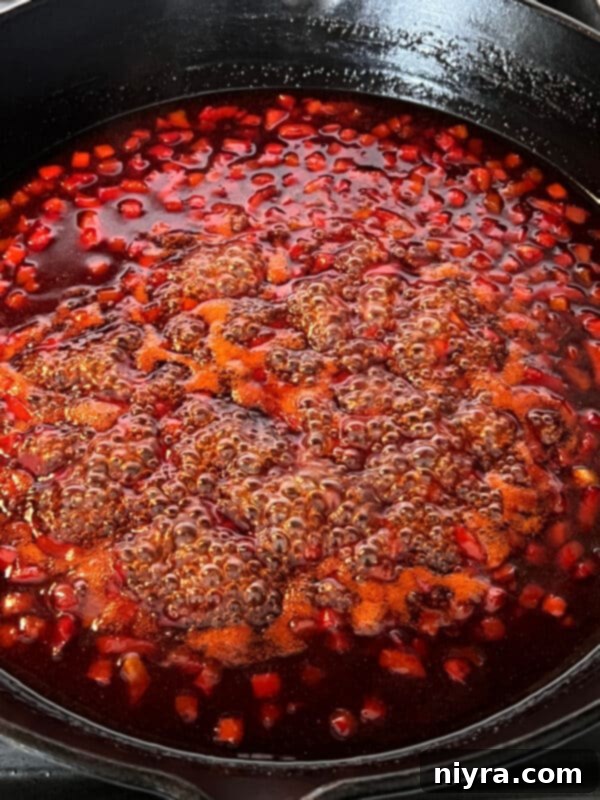 Sweet and sour sauce simmering with bell peppers