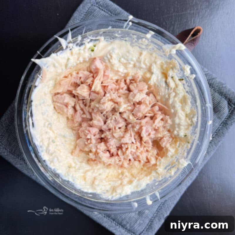 Savory Chicken Cracker Dip 6 Chicken meat being folded into the creamy dip mixture.