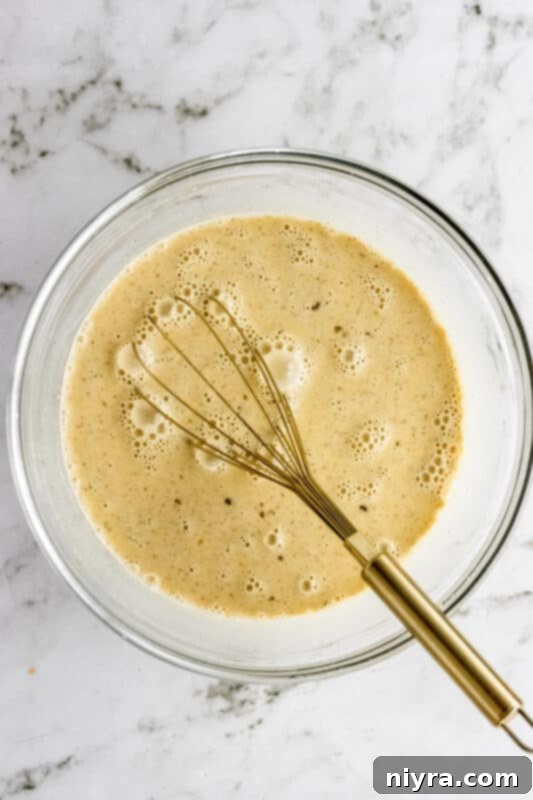 Crumb-Topped French Toast Casserole 7 Whisking the egg and milk mixture in a bowl