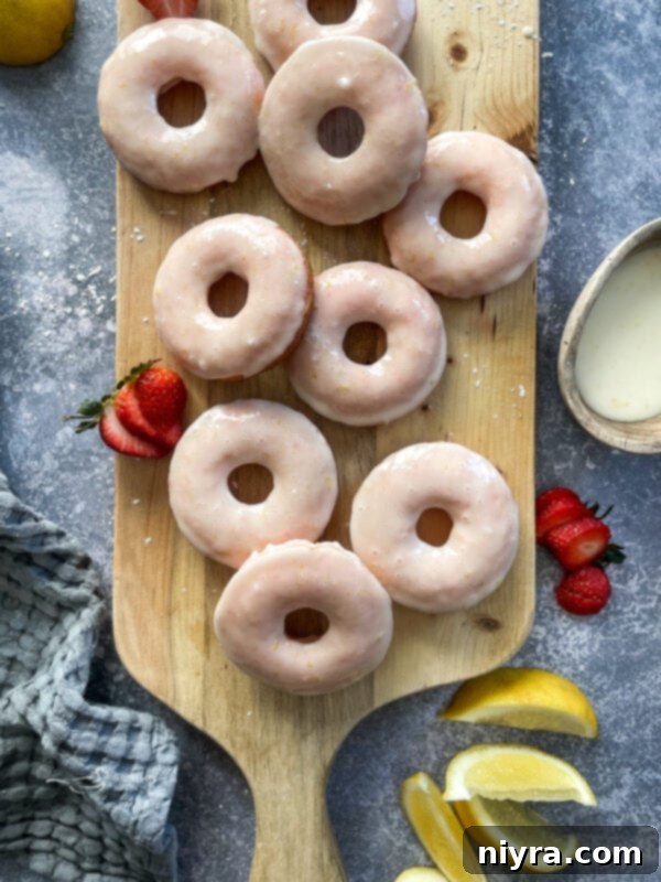 Close-up of baked strawberry lemonade donuts on a cooling rack.