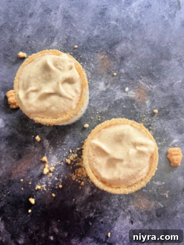 Step-by-step image of pouring Banana Cream Pie Shake into a prepared glass with a graham cracker rim.
