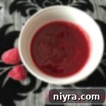 overhead of raspberry sauce in a white cup