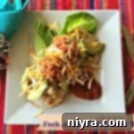 Overhead of dressed Taco on a white plate with text "Fork & Knife Chicken Tacos"