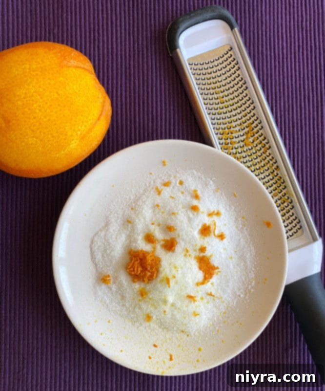 Close-up of orange zest being mixed with sugar on a plate for rimming a glass.