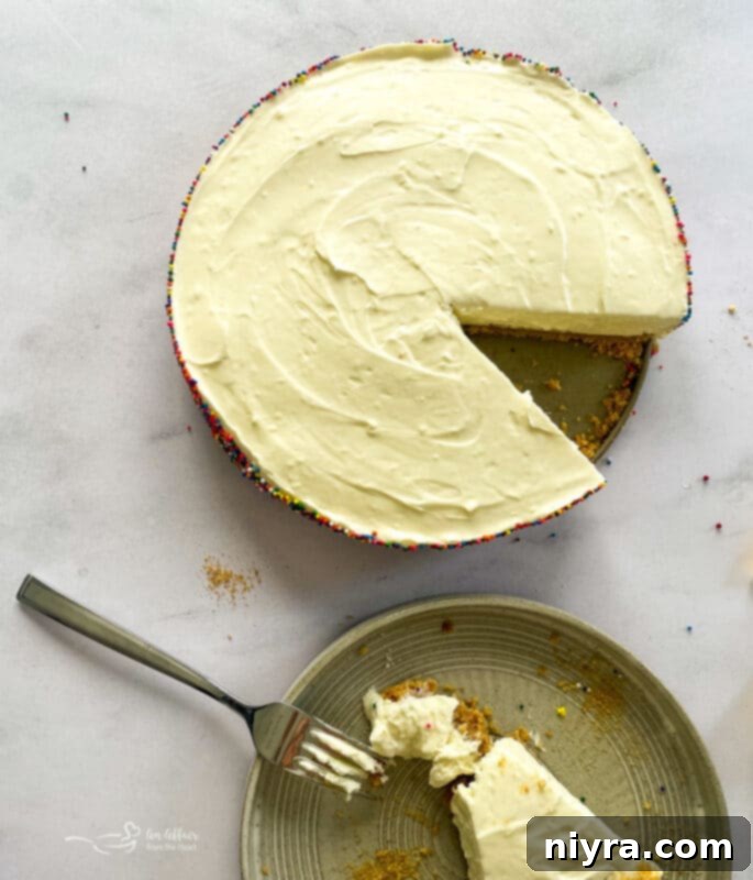 A No-Bake Marshmallow Cheesecake with one slice removed, revealing the creamy interior.